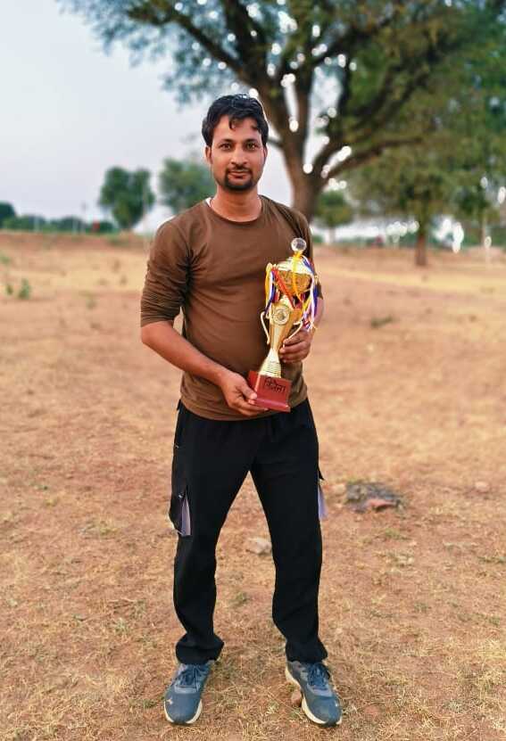 Bhojpura Kalan team player Ashish Sharma with the winning trophy of the tournament.