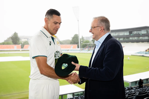 Australia PM XI player Scott Boland handing over the cap to the Prime Minister.